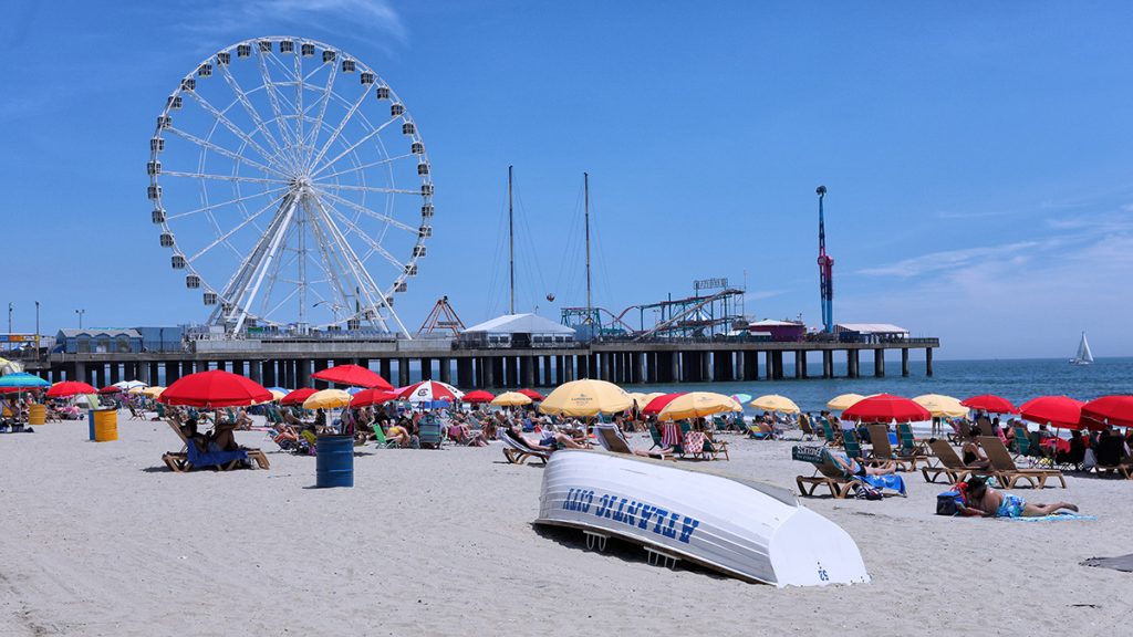 Atlantic City Beach during summer months with Atlantic City Lifeboat and Steel Pier in background.