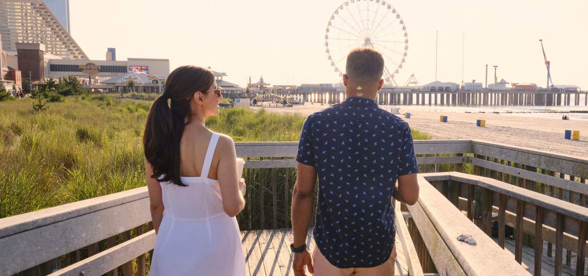 Couple walk down a beach entrance off the Atlantic City New Jersey Boardwalk.